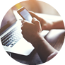 Cropped shot of a young man working from home using smart phone and notebook computer, side view of a man's hands using smart phone in interior,man at his coworking place using technology, flare light